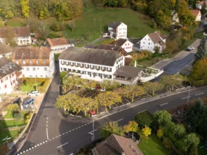 Luftaufnahme des Restaurants Bad Eptingen mit Hotel, Terrasse und umliegender Ortschaft in naturnaher Lage