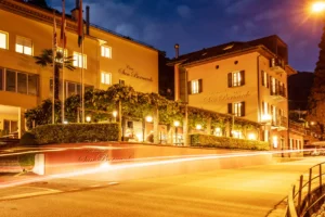 Beleuchtetes Gebaeude am Abend mit Aussenbereich und Restaurantbetrieb